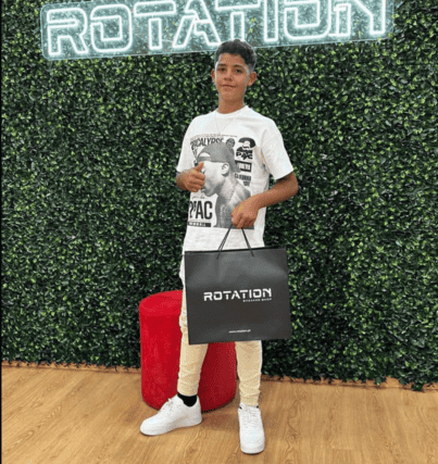 Cristiano Ronaldo Jr. striking a pose after a shopping spree, showcasing his trendy style and the remarkable growth spurt in his height.