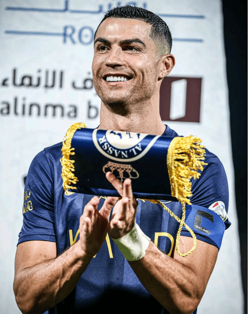 Captain Cristiano Ronaldo, leading Al Nasr with pride, stands tall with the team flag before a thrilling game.