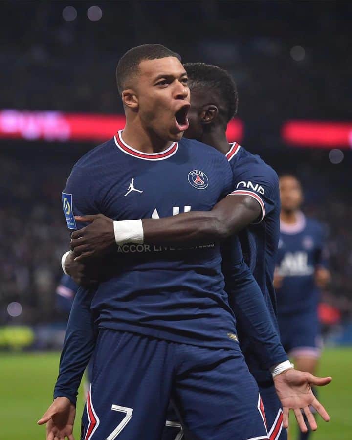 "Kylian Mbappe exuberantly celebrates a goal, pure joy radiating from his expressive face, a moment of triumph captured on the pitch.