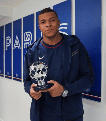 Kylian Mbappe proudly holds his UEFA Player of the Match award, a moment of recognition for his stellar performance on the football stage